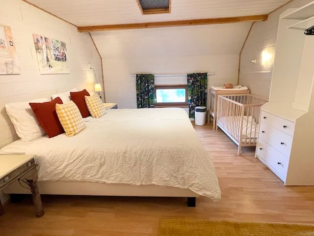 Schlafzimmer 2 mit einem Doppelbett, einem Einzelbett sowie Kinderbett und Wickeltisch
